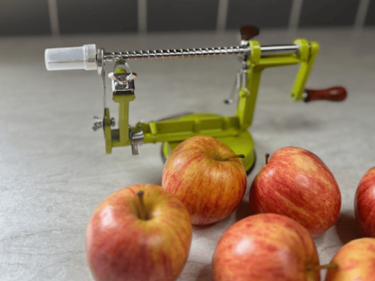 RSVP International green apple peeler with a fresh apple attached, peeling and slicing the apple for homemade apple crisp.