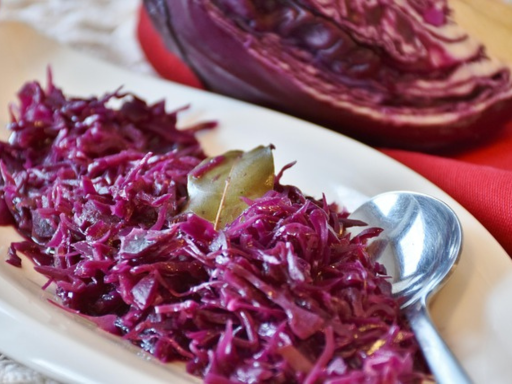 Sweet and tangy red cabbage with onions cooked in a skillet.