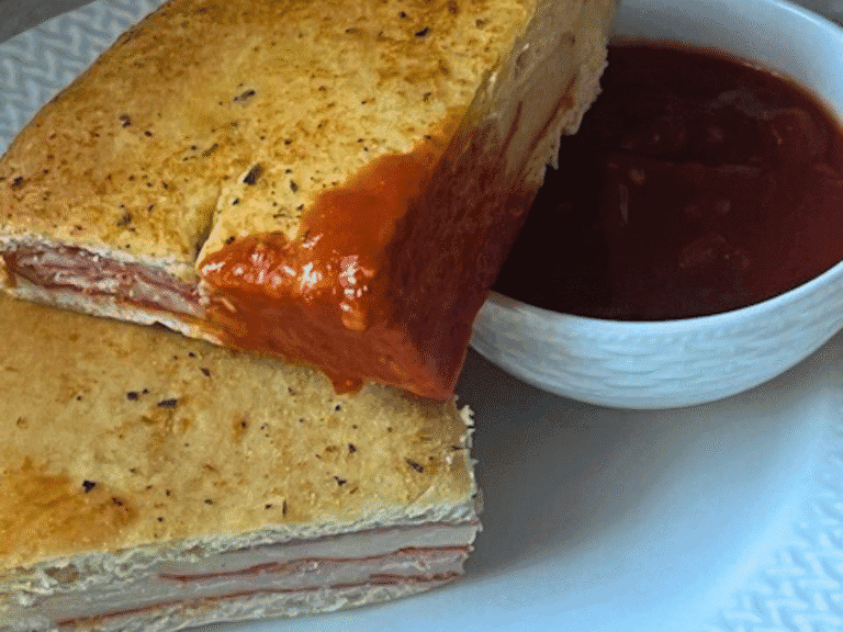 Homemade stromboli with pepperoni, salami, ham, cheese, and banana peppers sliced and ready to serve.