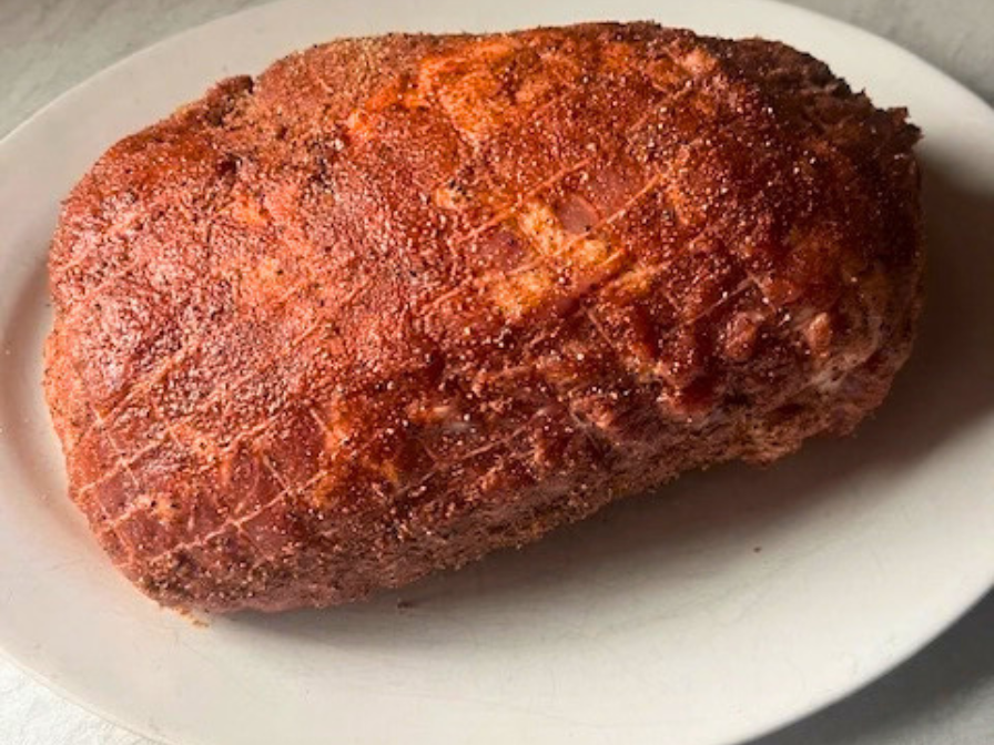 Raw pork shoulder coated with dry rub seasoning before searing for slow cooker pulled pork
