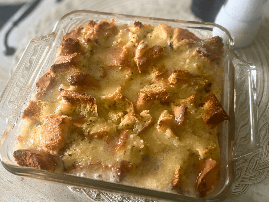 Homemade bread pudding baked in an 8x8 casserole dish with a brown butter drizzle on top