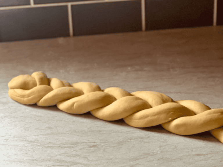 Braiding three strands of dough to form Hefekranz wreath bread