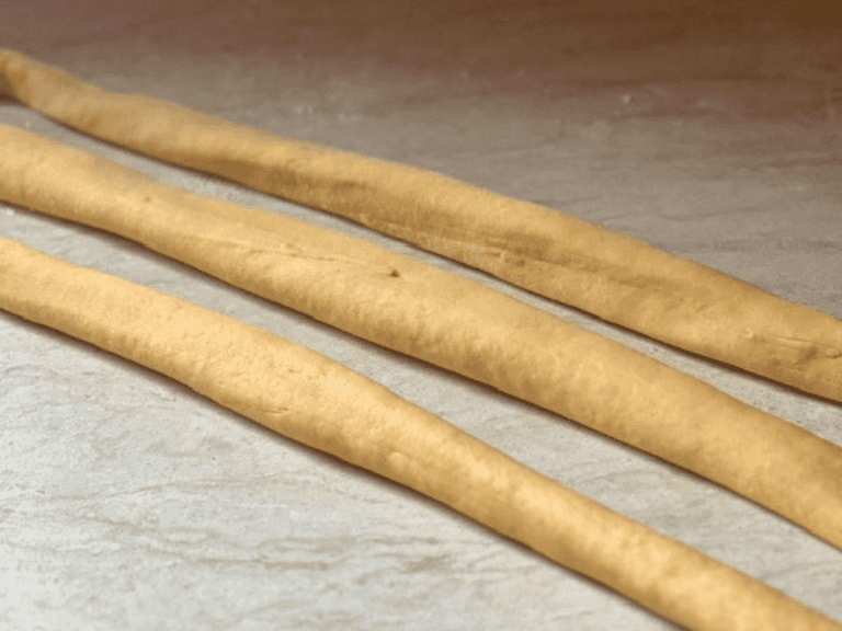 Three strands of dough rolled into long ropes for Hefekranz bread