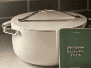Cream-colored Caraway 6.5-quart ceramic Dutch oven with lid sitting on a kitchen countertop.
