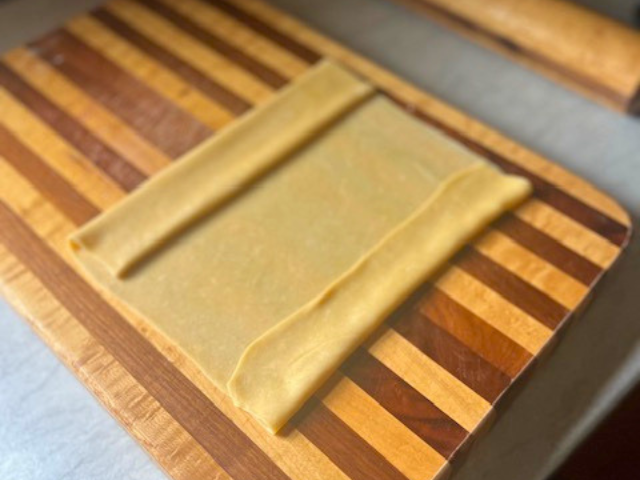 Both ends of homemade pasta dough folded toward the middle before slicing.
